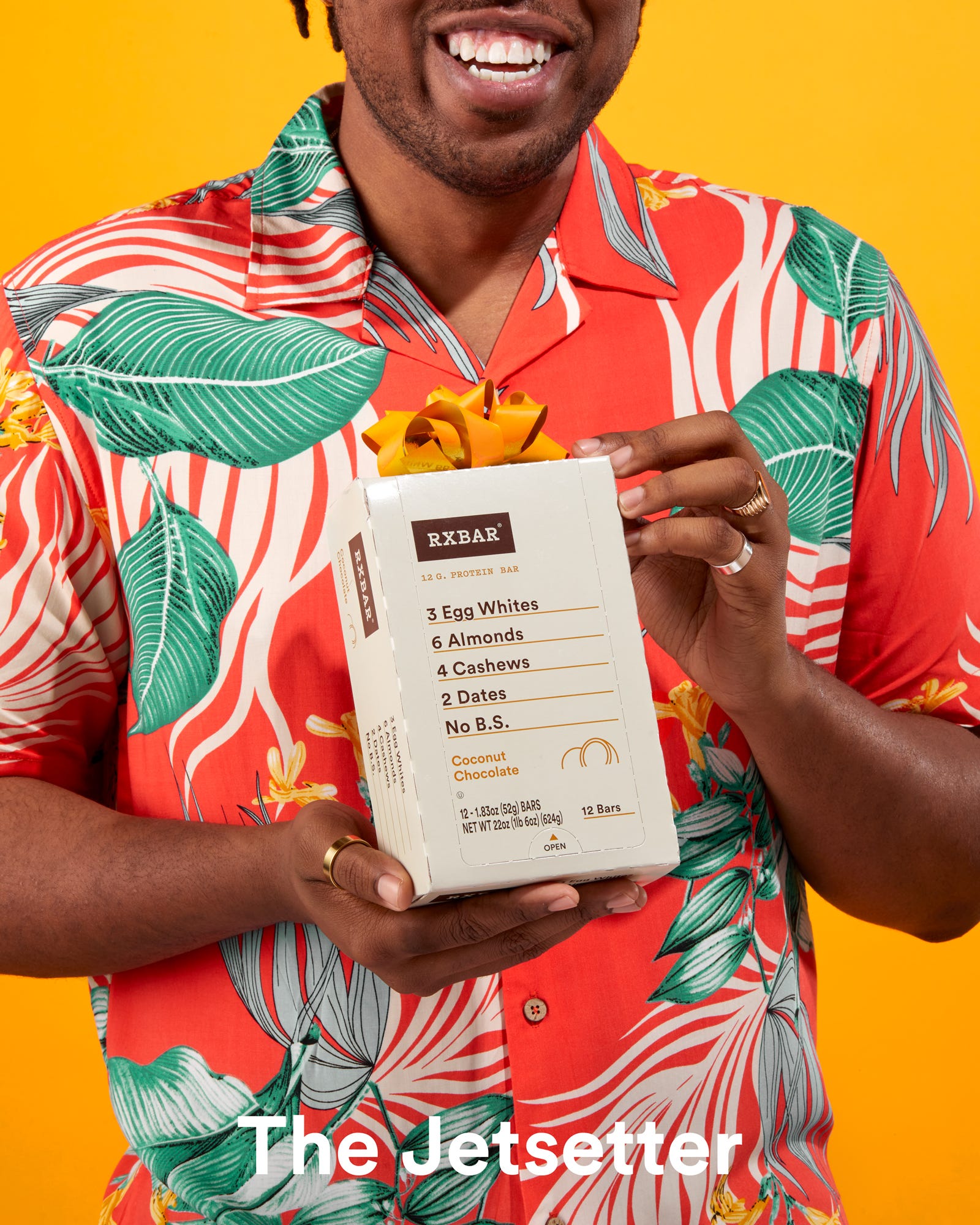 man in a flowery shirt holding an RX Bar package