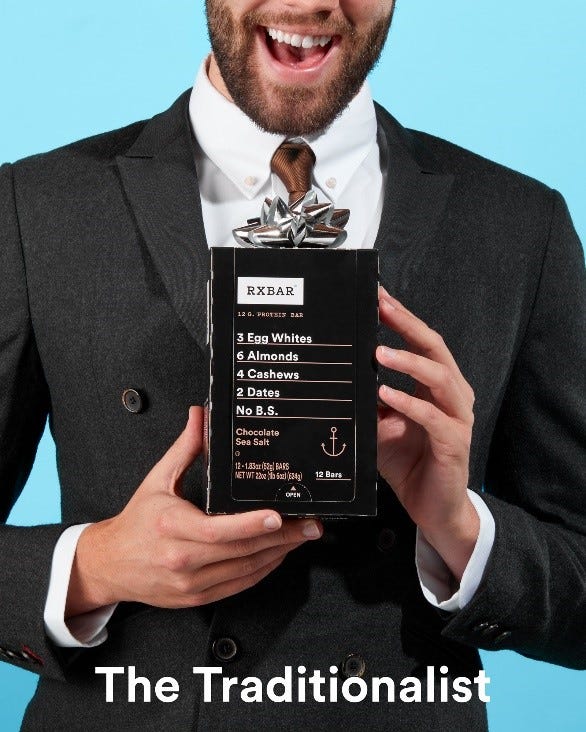 man in a suit holding an RX Bar box